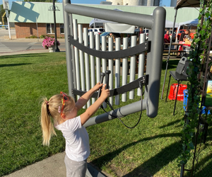 Little girl playing metal harp in Triangle Park