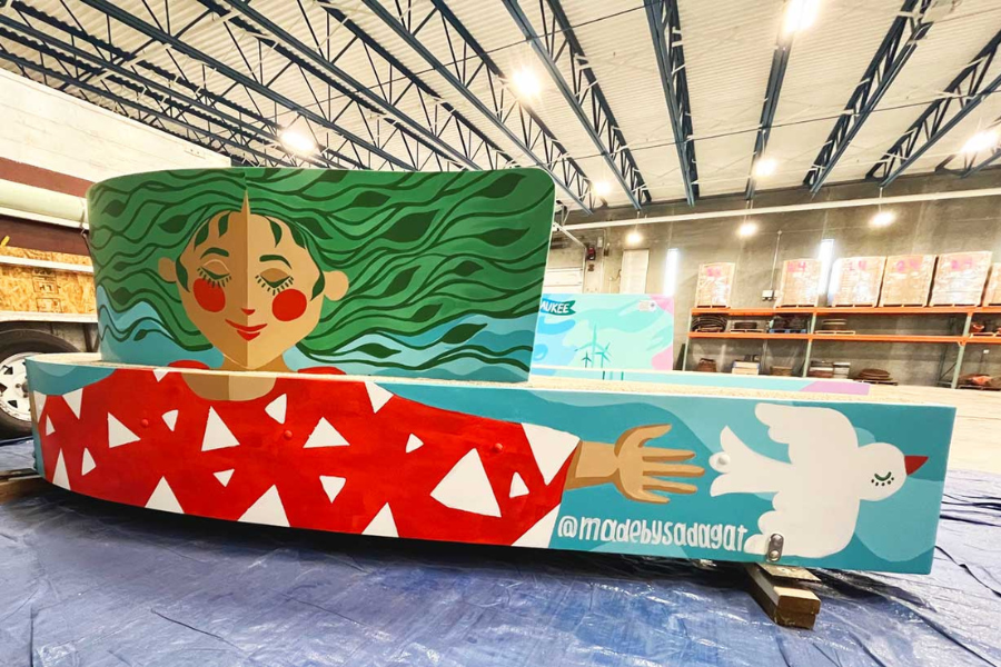 long bench painted with woman with leaves for hair and serene smile with arms wide open for a hug