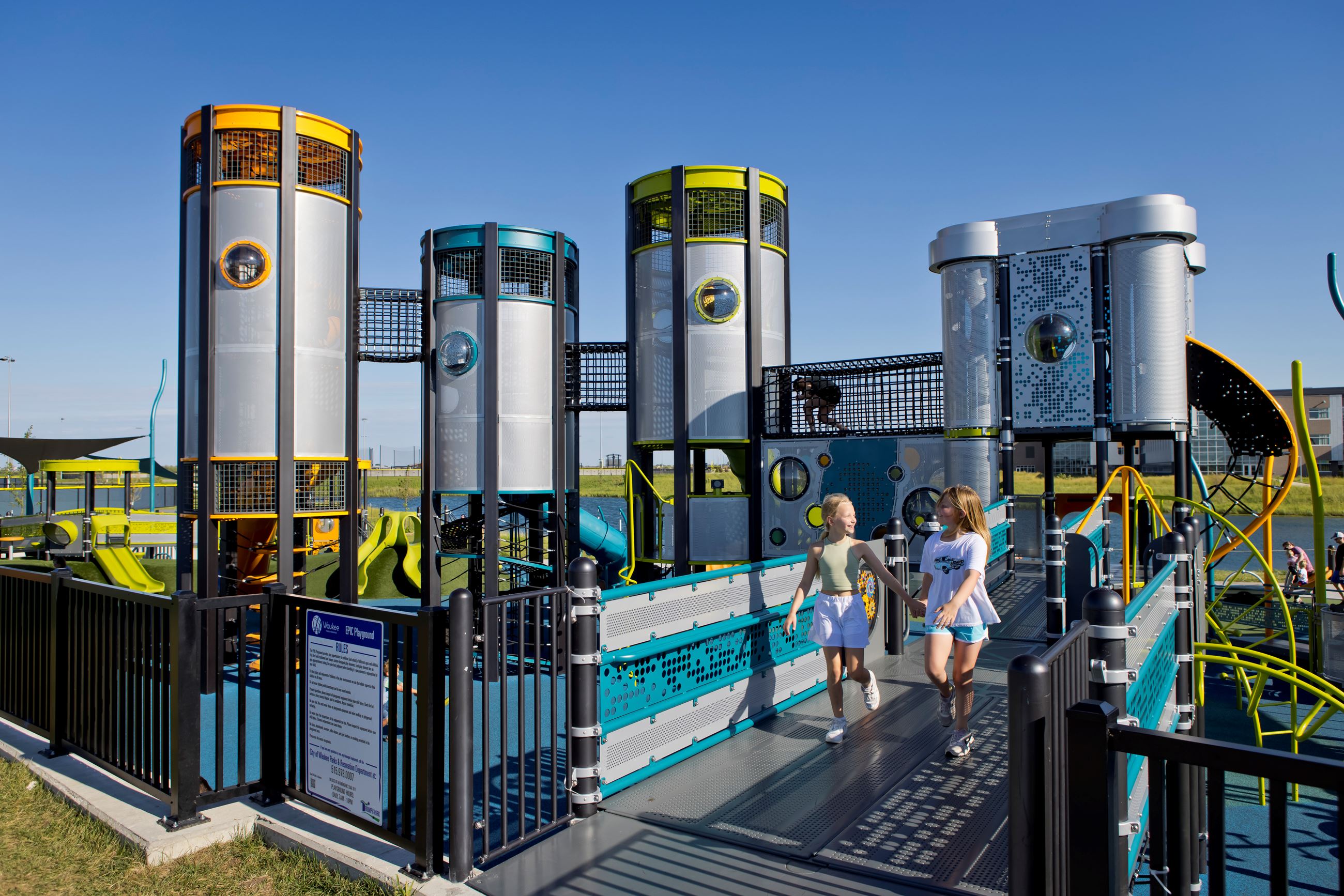 Two kids walk on the bridge entry to the play structure